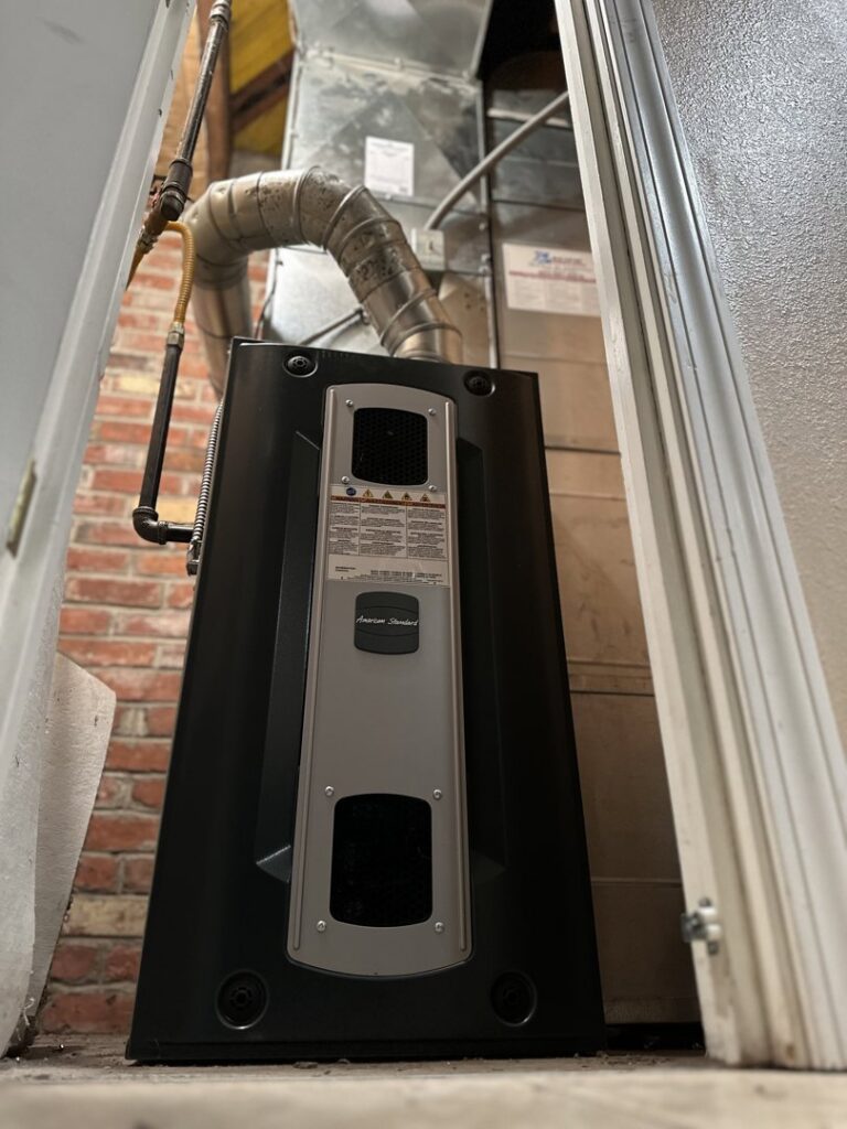 Indoor furnace unit with exposed metal ductwork in a residential setting by GreenFlow Heating & Cooling in Tacoma, WA