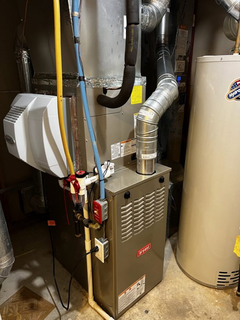 An indoor furnace and air handler unit with an attached humidifier and ductwork, installed by Simply Home Service in Gaithersburg, MD.