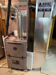 An indoor furnace unit with attached ductwork and branding, installed by A-1 HVAC in Kansas City, KS.