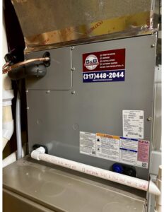 An indoor furnace unit with an S&B heating and cooling business sticker in Florence, KY.
