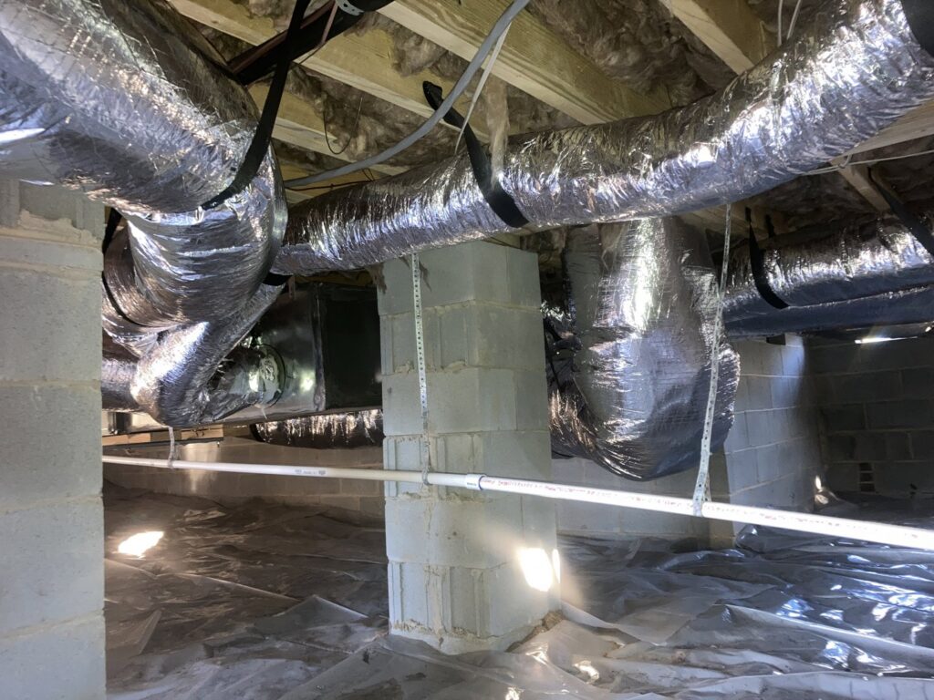 An indoor HVAC air handler unit with ductwork installed in a crawl space by Oakes AC Services, LLC in Louisburg, NC