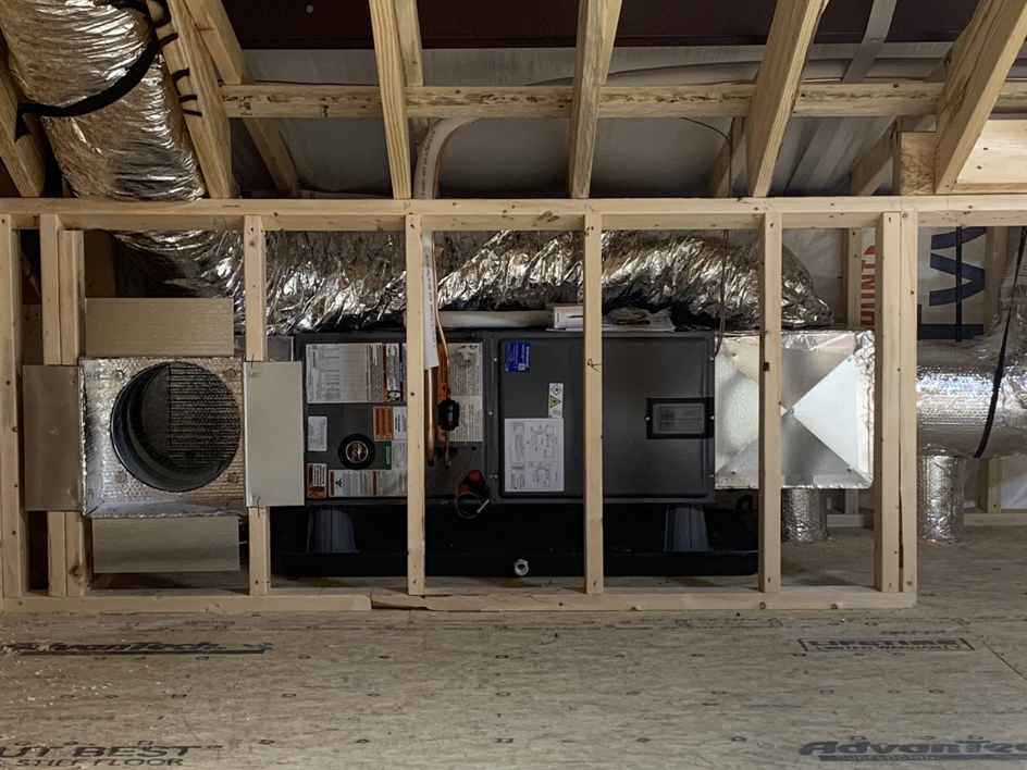 An indoor HVAC air handler unit and ductwork installed by Symbiont Services in Englewood, FL.
