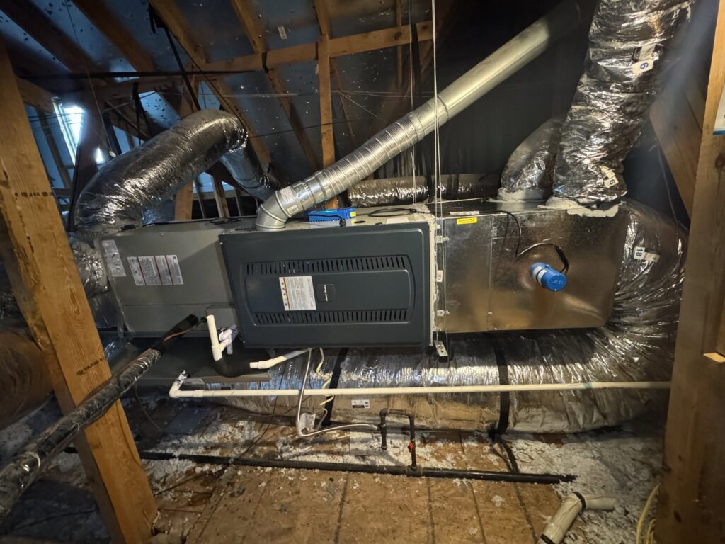 An indoor HVAC air handler unit with ductwork installed in an attic by Harlen Johnson Heating & Air in Dallas, TX.