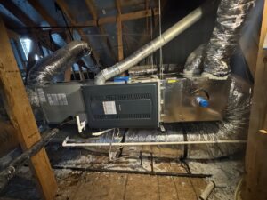 An indoor HVAC air handler unit with ductwork installed in an attic by Harlen Johnson Heating & Air in Dallas, TX.