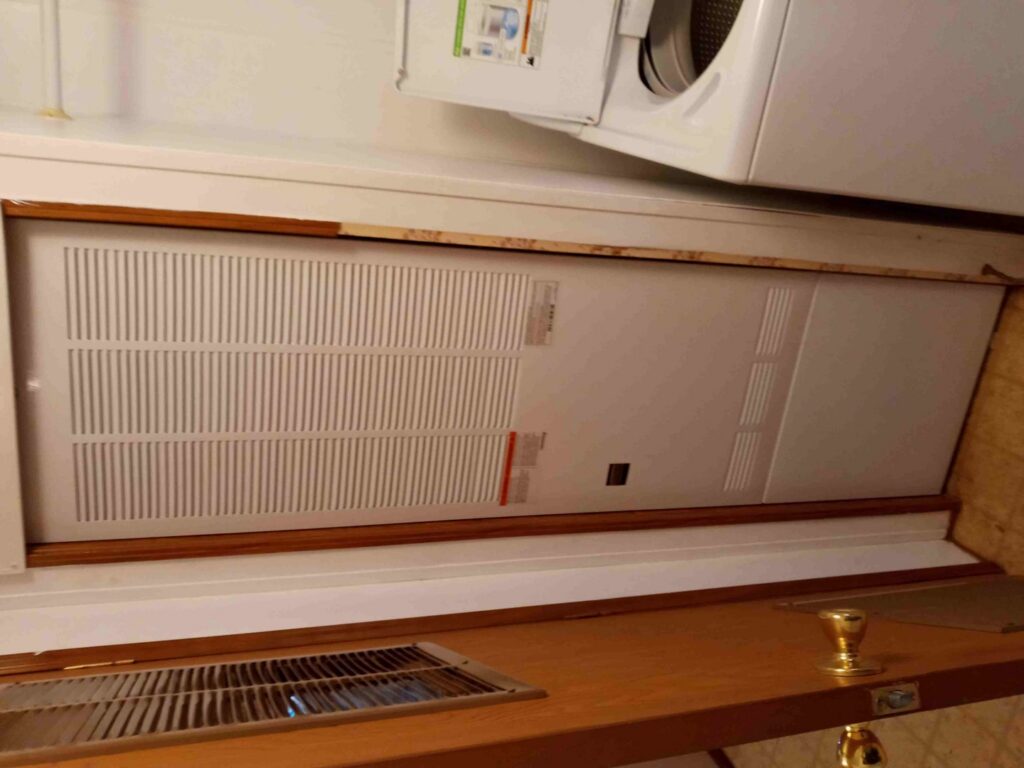 An indoor HVAC air handler or furnace unit installed in a laundry area by Jones Heating and Refrigeration in Dickinson, ND.