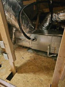 An indoor HVAC air handler unit with ductwork in an attic or crawl space by Grace Heating & Air in Clarksville, TN.