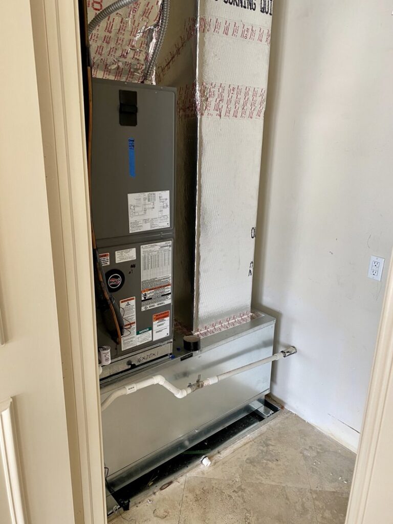 An indoor HVAC air handler unit with ductwork installed in a utility space by T&D Air Conditioning in Fort Lauderdale, FL.