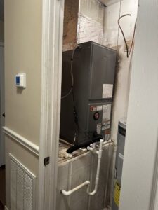 An indoor HVAC air handler unit installed in a utility closet by Budget Heating and Air in Mobile, AL.