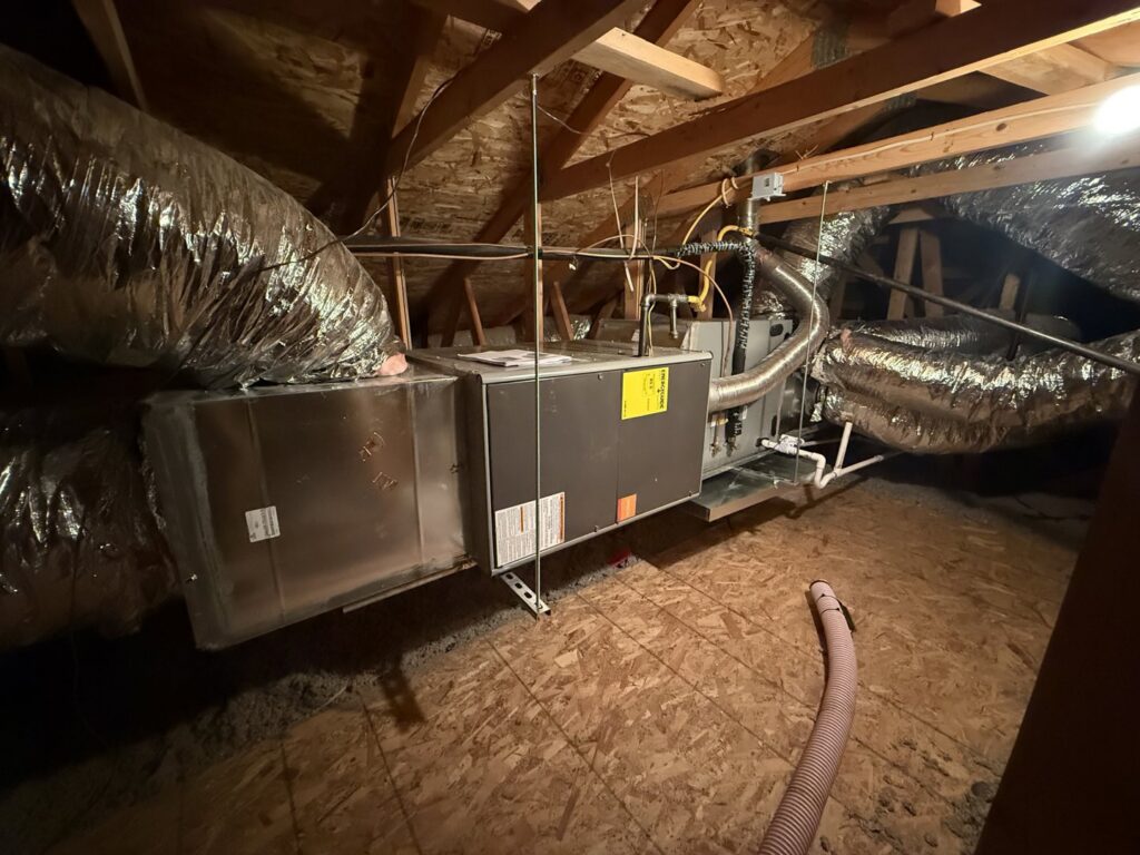 An indoor HVAC furnace and air handler unit installed in an attic with connected ductwork by Blue Collar Mechanical LLC in Indianapolis, IN.