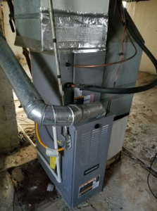 An indoor HVAC furnace and air handler unit with ductwork installed by Harbrecht HVAC in Fishers, IN.