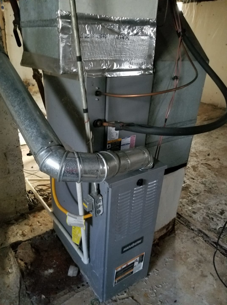 An indoor HVAC furnace and air handler unit with ductwork installed by Harbrecht HVAC in Fishers, IN.