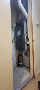 An indoor HVAC furnace unit installed in a utility closet by A1 Mechanical Heating and Cooling Services in Waynesville, OH.