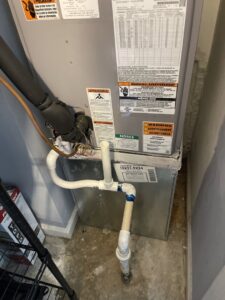 An indoor HVAC furnace unit with piping and ductwork, installed by Gregory's Heating & Cooling in Chesapeake, VA.