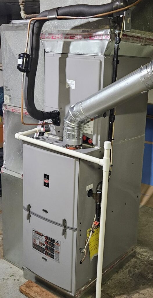 An indoor HVAC furnace system with connected ductwork and refrigerant lines, serviced by Astron Services LLC in Wichita, KS.