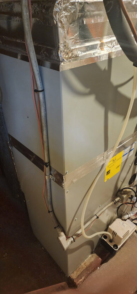 An indoor HVAC furnace system with ductwork and piping, installed by C&L Heating and Air in Louisville, KY.