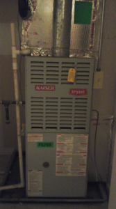 An indoor HVAC furnace unit with a filter reminder sticker, serviced by Harbrecht HVAC in Fishers, IN.