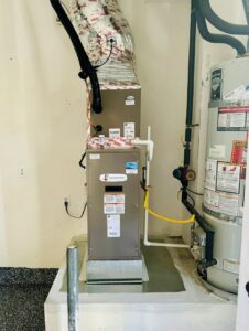 An indoor HVAC furnace and water heater installed in a utility space by Pelican Heating and Air in Carlsbad, CA.