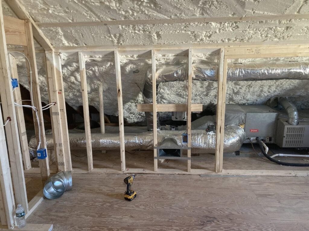 An indoor HVAC system with ductwork and insulation being installed in an attic by Freedom Air Mechanical Contractors LLC in Everett, MA.