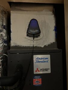 An indoor HVAC unit with ductwork and a Halo-LED air purifier, installed by Goettl Austin in Austin, TX