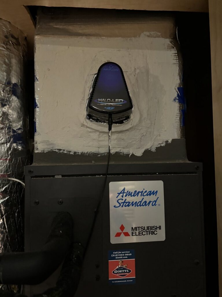 An indoor HVAC unit with ductwork and a Halo-LED air purifier, installed by Goettl Austin in Austin, TX