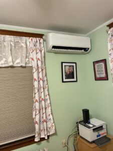 An indoor HVAC mini-split unit installed on a wall in a room by Laird's HVAC in Auburn, ME.