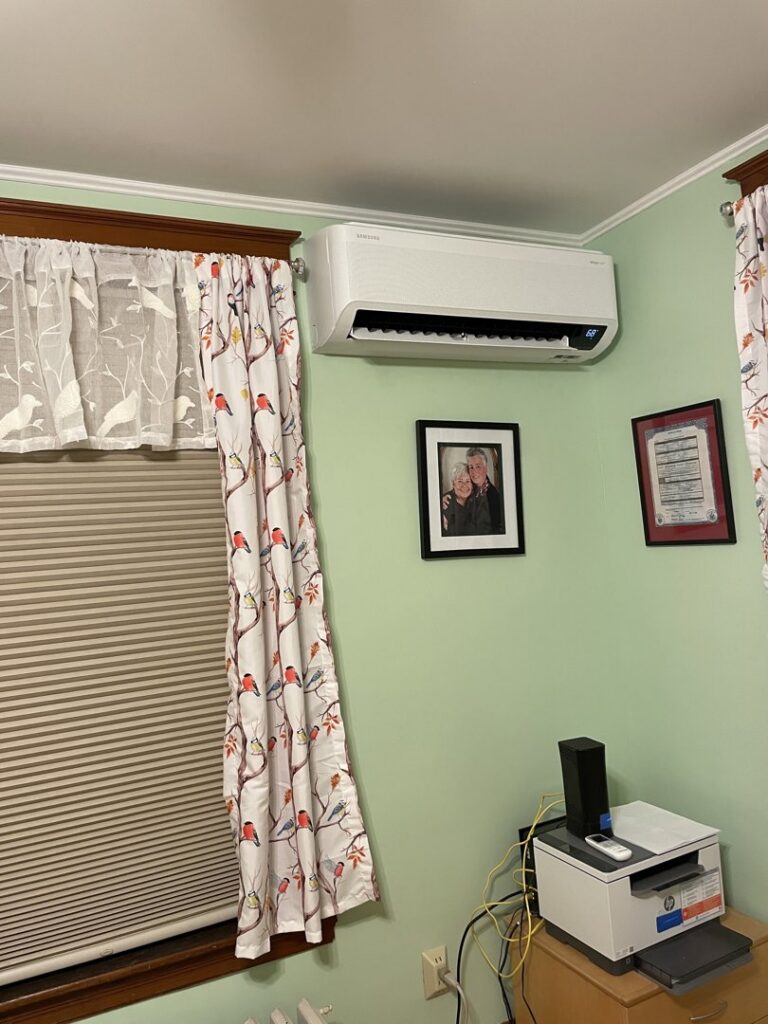 An indoor HVAC mini-split unit installed on a wall in a room by Laird's HVAC in Auburn, ME.