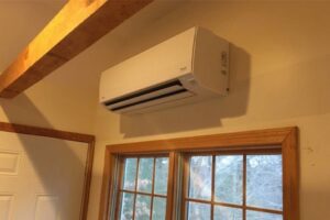 An indoor mini-split AC unit professionally installed above a window by Cooler Solutions LLC Heating & Air in Gulfport, MS.