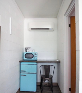 An indoor mini-split air conditioning unit installed above a small kitchenette area by ProMasters HVAC Mechanical in New York, NY