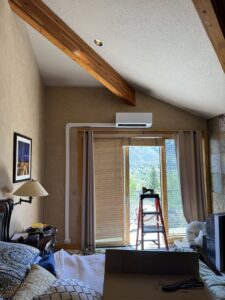 An indoor mini-split head unit installed above a sliding door in a room by EPIC Heating and Air in Loveland, CO