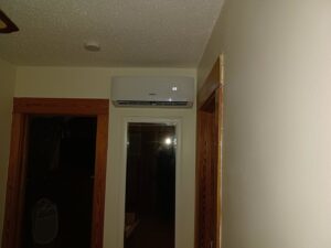 An indoor mini-split HVAC unit installed above a doorway in a hallway by Jones Heating and Refrigeration in Dickinson, ND.