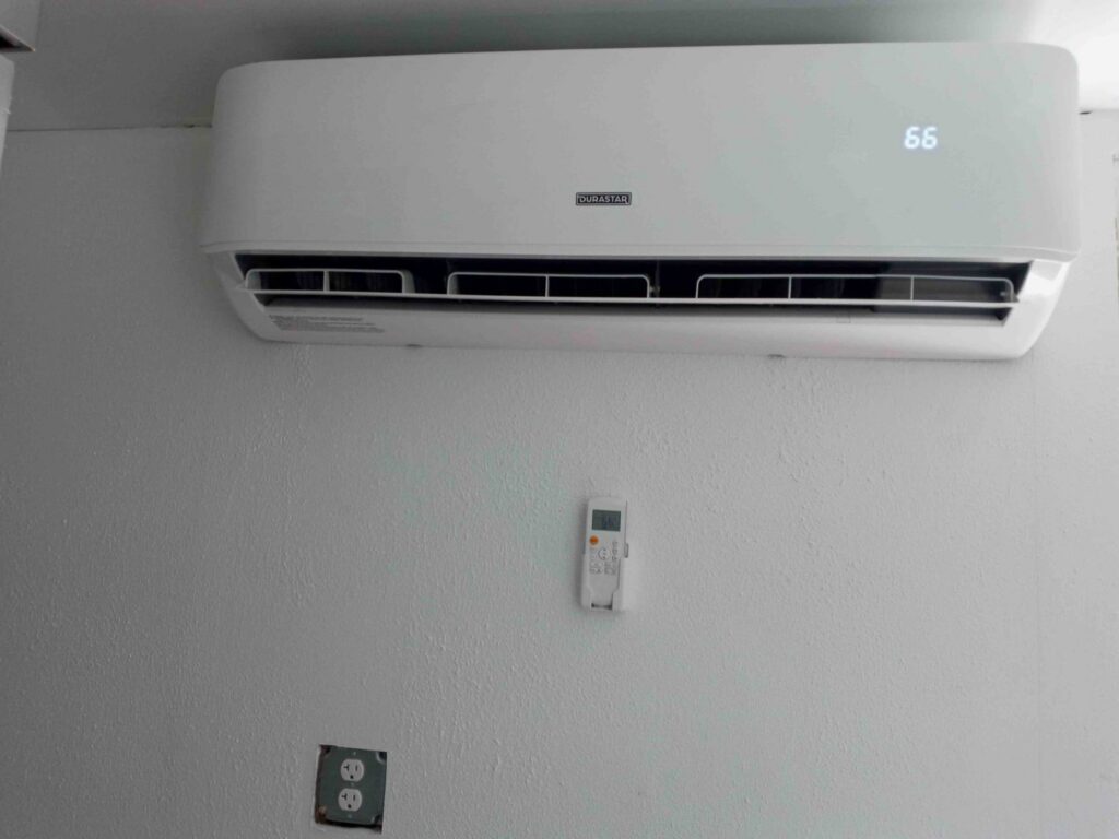 An indoor mini-split HVAC unit with its remote control installed on a white wall by Jones Heating and Refrigeration in Dickinson, ND.