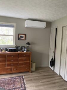 An indoor mini-split heat pump unit installed in a bedroom with light-colored walls by Champlain Valley Heat Pump, LLC in Colchester, VT.