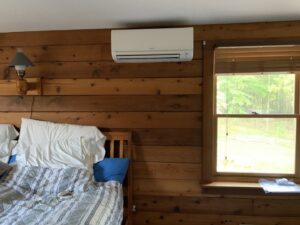 An indoor wall-mounted Mitsubishi mini-split unit installed in a bedroom by Superior CO-OP HVAC in Cambridge, NY.