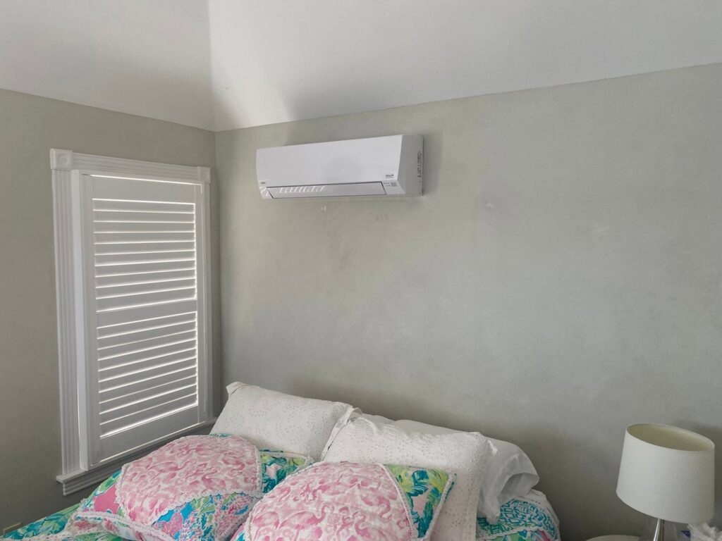 An indoor mini-split HVAC unit installed above a bed in a bedroom by Tom's Heating & Air Conditioning LLC in Lacey Township, NJ.
