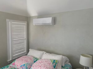 An indoor mini-split HVAC unit installed above a bed in a bedroom by Tom's Heating & Air Conditioning LLC in Lacey Township, NJ.