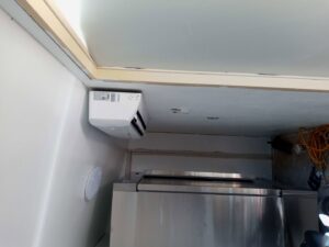 An indoor mini-split air conditioning unit mounted high in a room corner, installed by Jones Heating and Refrigeration in Dickinson, ND.