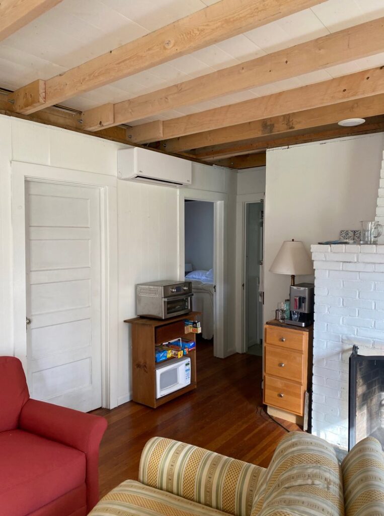 An indoor mini-split heat pump unit installed in a living area with exposed beams by Champlain Valley Heat Pump, LLC in Colchester, VT.