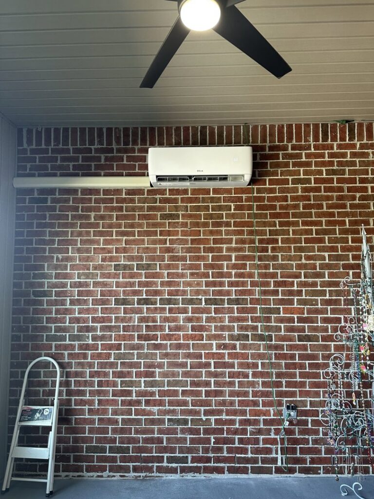 An indoor mini-split unit installed on a brick wall by Budget Heating and Air in Mobile, AL.