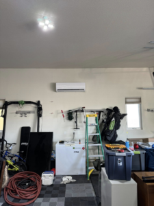 An indoor mini-split air conditioning unit installed on a garage wall by Golden Heating and Air LLC in Arvada, CO.