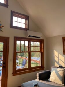 An indoor mini-split heat pump unit installed in a room with large windows by Champlain Valley Heat Pump, LLC in Colchester, VT.