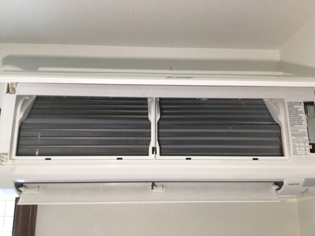 An indoor mini-split unit with its cover open, revealing internal components for service by Sound Comfort Heating & Air Conditioning in Everett, WA.