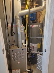 An indoor Payne HVAC furnace and water heater system installed by Carter HVAC & Service in Seagrove, NC.