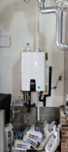 An indoor tankless water heater professionally installed on a wall by Cannon Heating and Air Conditioning, LLC in Newport News, VA.