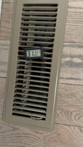 An indoor vent with a digital display showing temperature and humidity, indicating HVAC system performance by A/C Company Since 1988 in Murfreesboro, TN.