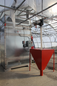 A large industrial biomass boiler system installed in a greenhouse, demonstrating heating solutions by Kedel Boilers in Portland, ME.