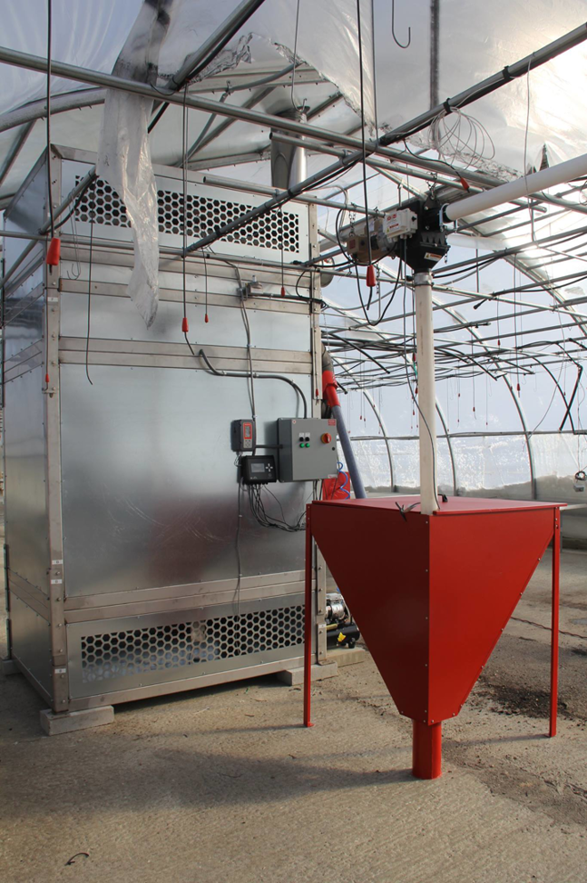 A large industrial biomass boiler system installed in a greenhouse, demonstrating heating solutions by Kedel Boilers in Portland, ME.