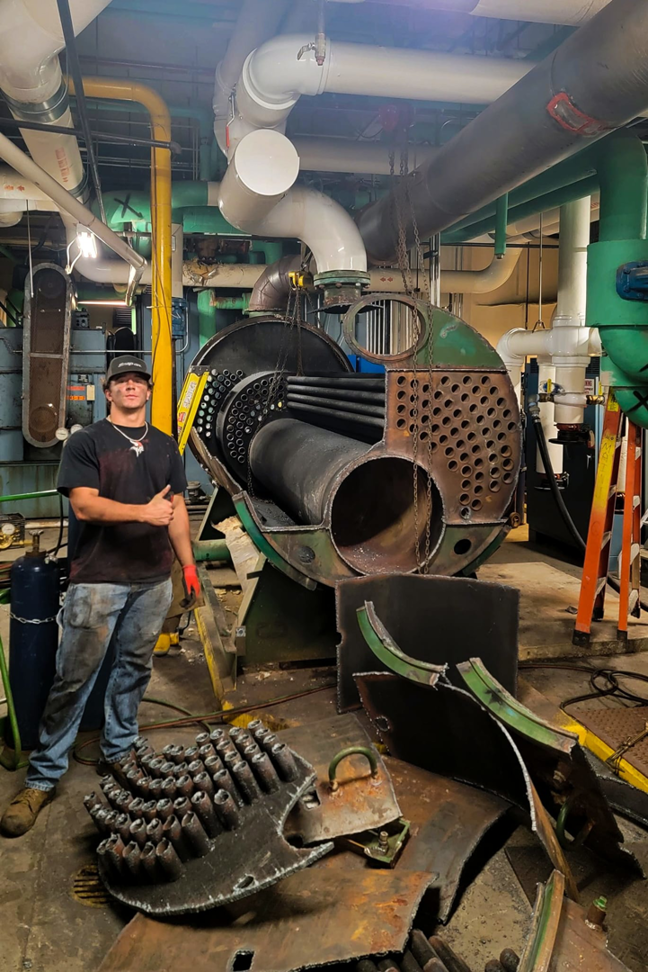 An HVAC technician performing an industrial boiler repair for Boardwell Mechanical Services Inc. in Montague, MI