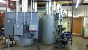 Large industrial boilers and associated piping in a mechanical room, serviced by KCM Heating & Air Conditioning in Omaha, NE.