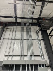 Industrial ceiling with multiple electrical conduits and lighting fixtures installed by Patriot Electric L.L.C in Phoenix, AZ