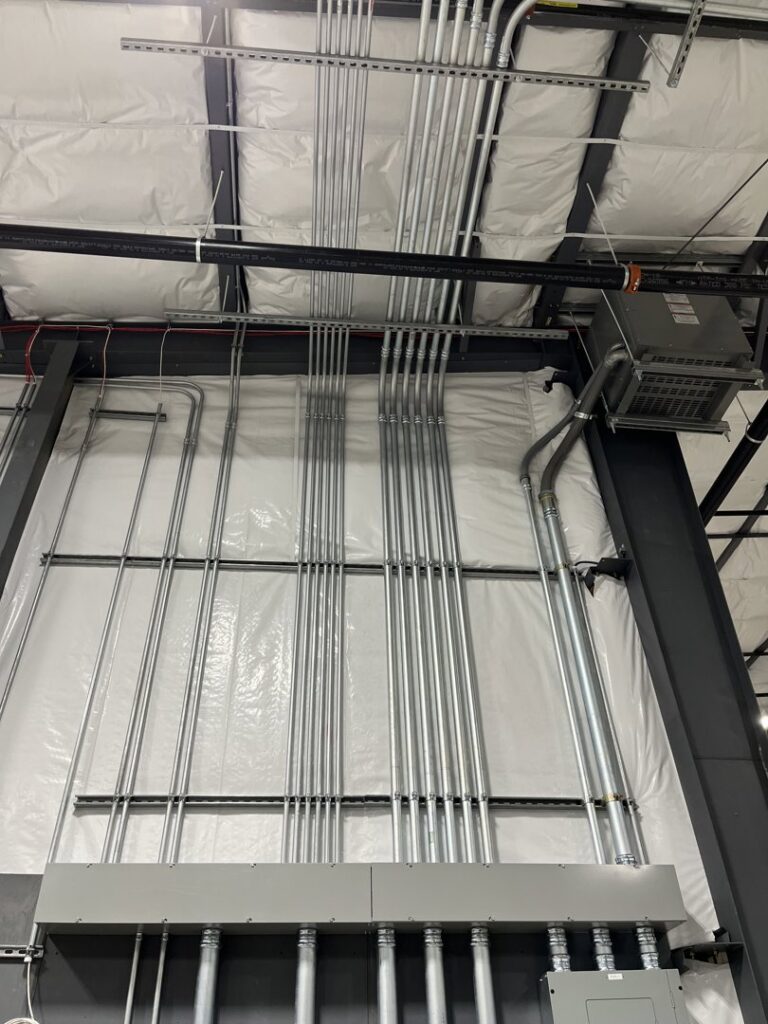 Industrial ceiling with multiple electrical conduits and lighting fixtures installed by Patriot Electric L.L.C in Phoenix, AZ